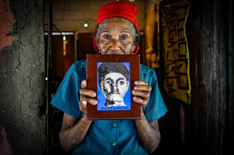 Soledad Ruiz holds an image of her son Apolinar Silgado Ruiz, a victim of paramilitaries in Colombia. After searching for him for 24 years ago, she received his remains in a small coffin at her home in San Onofre. AFP