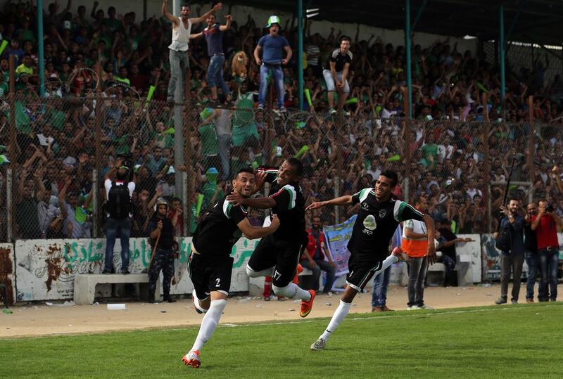 Palestinians cheer after players from Al Shujaiya score during their Gaza Strip Cup final against Rafah Club in Gaza City, on June 7, 2015. Mahmud Hams / AFP