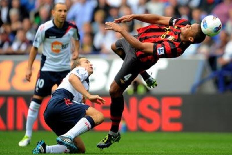 Manchester City’s Vincent Kompany, right, tries to gain control of the ball.