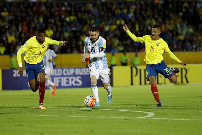 Lionel Messi, centre, dribbles the ball between Robert Arboleda, left, and Jefferson Intriago. Fernando Vergara / AP Photo