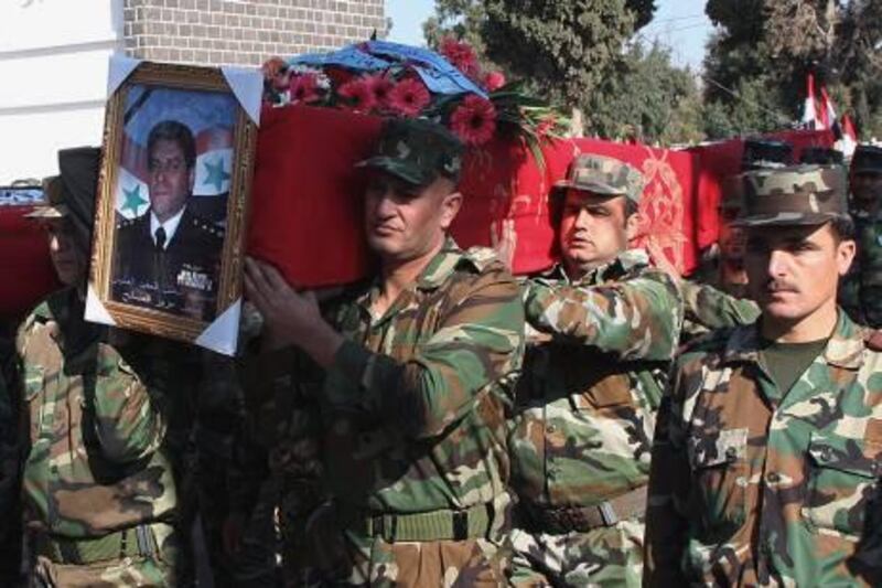 In this photo taken during a government-organized tour for the media, Syrian army officers carry the coffin of one of the 17 army members, including six elite pilots and four technical officers who the military said were killed in an ambush on Thursday during their funeral procession, in Homs province, Syria, on Saturday Nov. 26, 2011. The military blamed terrorists for the ambush and has vowed to "cut every evil hand" that targets the country's security. Syria is facing mounting international pressure to end a bloody crackdown on an uprising against the rule of President Bashar Assad that the U.N. says has killed more than 3,500 people. The Arab League was meeting Saturday to consider the possibility of sweeping economic sanctions. (AP Photo/Bassem Tellawi) *** Local Caption ***  Mideast Syria.JPEG-0346b.jpg