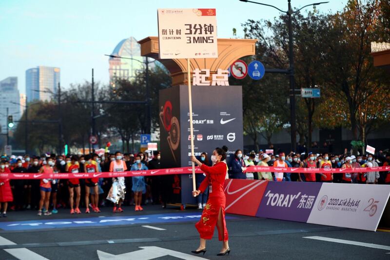 A woman holds a countdown placard before the start of the 2020 Shanghai marathon. AFP