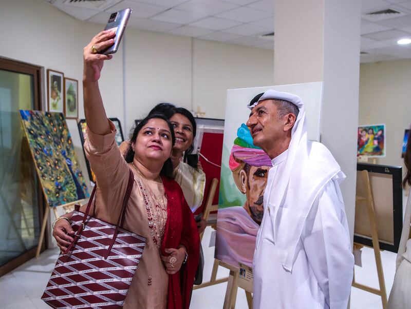 Indian residents take a selfie with artist Ahmed Al Awadhi. 