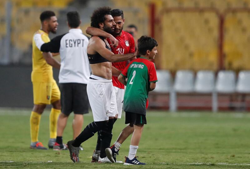 Salah gives his shirt to a young fan after the match. Reuters