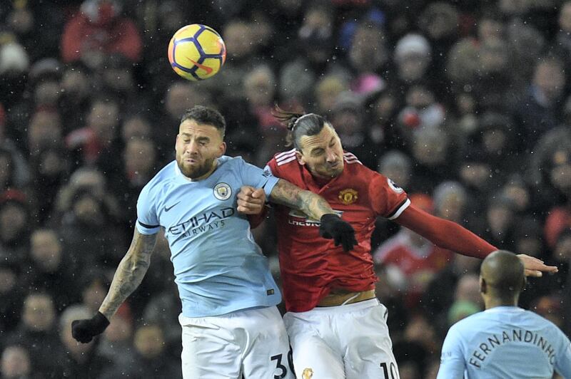 Manchester United's Swedish striker Zlatan Ibrahimovic (R) challenges Manchester City's Argentinian defender Nicolas Otamendi (L) in the air during the English Premier League football match between Manchester United and Manchester City at Old Trafford in Manchester, north west England, on December 10, 2017. / AFP PHOTO / Oli SCARFF / RESTRICTED TO EDITORIAL USE. No use with unauthorized audio, video, data, fixture lists, club/league logos or 'live' services. Online in-match use limited to 75 images, no video emulation. No use in betting, games or single club/league/player publications.  / 