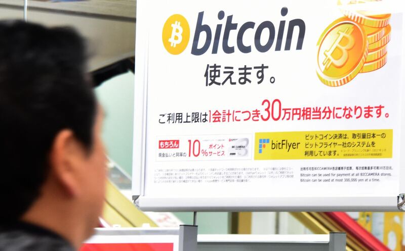 A man walks past a poster that informs customers that bitcoin can be used in this shop in Tokyo on January 06, 2018.
Bitcoin is recognised as legal tender in the world's third-biggest economy and nearly one third of global bitcoin transactions in December were denominated in yen, according to specialised website jpbitcoin.com / AFP PHOTO / Toru YAMANAKA / TO GO WITH AFP STORY:  Japan-economy-bitcoin-forex, FOCUS by Ayaka MCGILL / Etienne BALMER