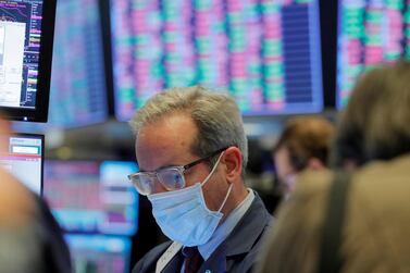 A trader wearing a mask on the floor of the New York Stock Exchange last week before it temporarily closed in a bid to stop the spread of coronavirus. Some US states have already issued shutdown orders to prevent the spread of the virus. Reuters.