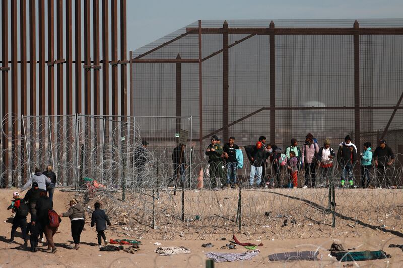 Migrants try to cross the border that divides Mexico from the US, in Ciudad Juarez. EPA