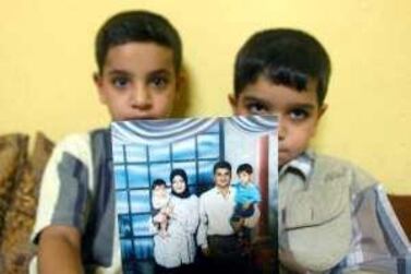 Baha Mousa, who died in UK military custody, features in a family photo held by his sons. AFP