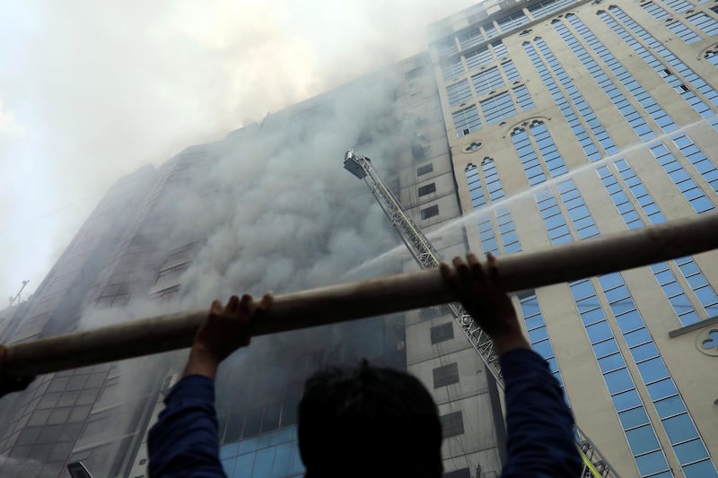 A person looks on as firefighters attempt to extinguish the fire. Reuters