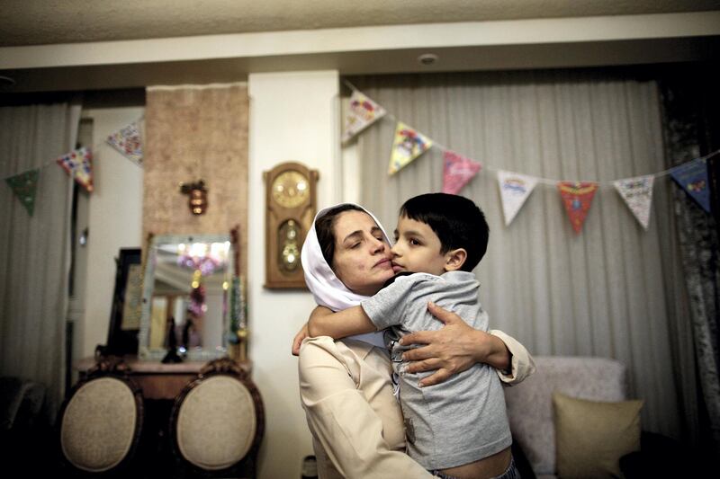 Iranian lawyer Nasrin Sotoudeh hugs get son Nima at her home in Tehran on September 18, 2013, after being freed after three years in prison. Sotoudeh told AFP she was in "good" physical and psychological condition, and pledged to continue her human rights work. Her release came a week before Iran’s new moderate President Hassan Rowhani, who has promised more freedoms at home and constructive engagement with the world, travels to New York to attend the United Nations General Assembly.  AFP PHOTO/BEHROUZ MEHRI (Photo by BEHROUZ MEHRI / AFP)