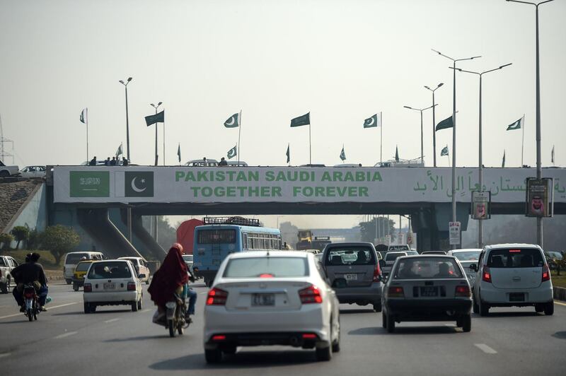 Pakistani commuters drive their vehicles under a banner welcoming Mohammed bin Salman in Islamabad. AFP