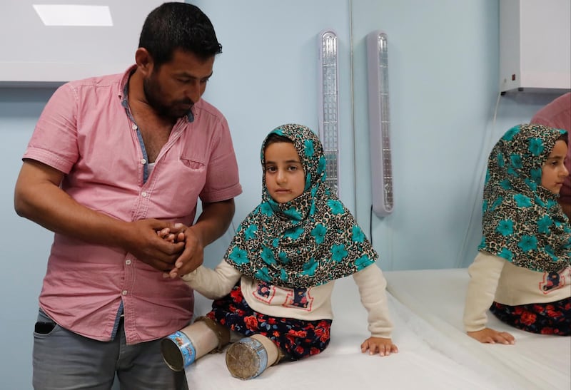 Maya's uncle, Hussein, waits with her at the clinic. Reuters