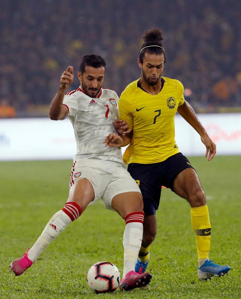 UAE's goalscoring hero Ali Mabkhout, left, holds off the challenge of La'Vere Corbin-Ong. AP