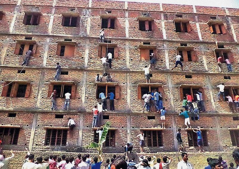 Indian relatives climb the wall of a building to help students appearing in an examination in Hajipur, in the eastern Indian state of Bihar. Even with police presence, parents and relatives are reported to scale building walls in order to pass notes to help students cheat in their exams. AP Photo / Press Trust of India 