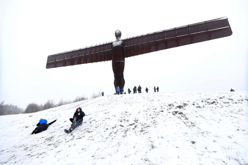 People sledge under the Angel of the North in Gateshead, England. Owen Humphreys/PA via AP