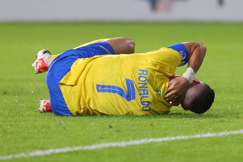 Al Nassr's Portuguese forward Cristiano Ronaldo lies on the pitch in pain after a collision with Persepolis goalkeeper Alireza Beiranvand during the AFC Champions League Group E match at the Al Awwal Stadium in Riyadh on November 27, 2023.  AFP