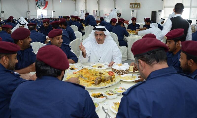 Sheikh Saif bin Zayed, Deputy Prime Minister and Minister of Interior, eats lunch with members of the Gulf Waves task force, part of a joint GCC military force in Bahrain, during a visit to the country on April 6, 2014. Courtesy Security Media
