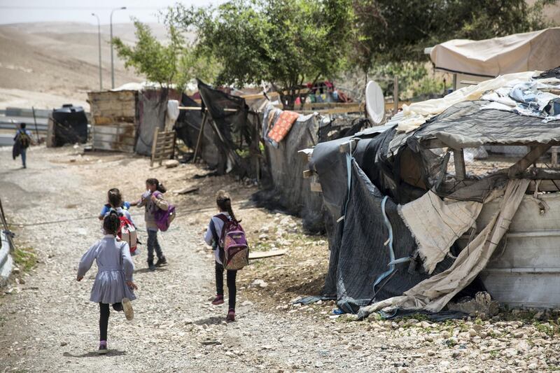 Beduin children pass by the shanty homes  in the tiny West Bank Beduin village of Khan al-Ahmar  on May 2,2018.The Israeli Supreme Court is expected next week to rule on the fate of the village, situated east of Jerusalem between the expanding settlements of Maale Adumim and Kfar Adumim.  The Israeli state says Khan al-Ahmar must be leveled because its structures are situated on state land and were built without permits, which are nearly impossible to obtain in the part of the West Bank known as area C, under full Israeli control.(Photo by Heidi Levine for The National).