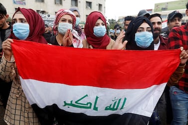Iraqi women carry the national flag during anti-government protests in Baghdad on February 25, 2020. Reuters 