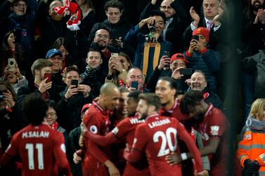 Fans take photographs of the Liverpool players after Virgil van Dijk scores the fifth goal against Watford. EPA