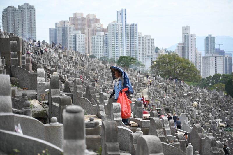 A worker cleans graves in a cemetery in Diamond Hill in Hong Kong during the Chung Yeung Festival. AFP