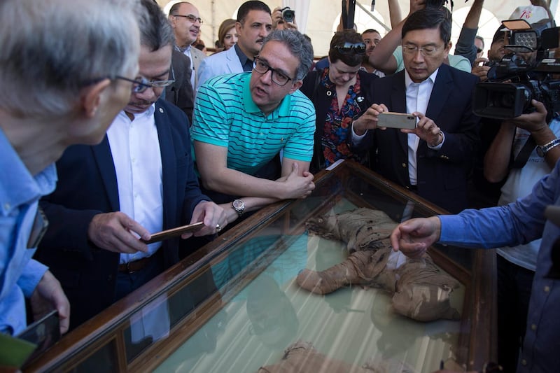 Egypt's Minister of Antiquities Khaled el-Anany, centre, said digs were uncovering 'hundreds of objects' in the area. EPA