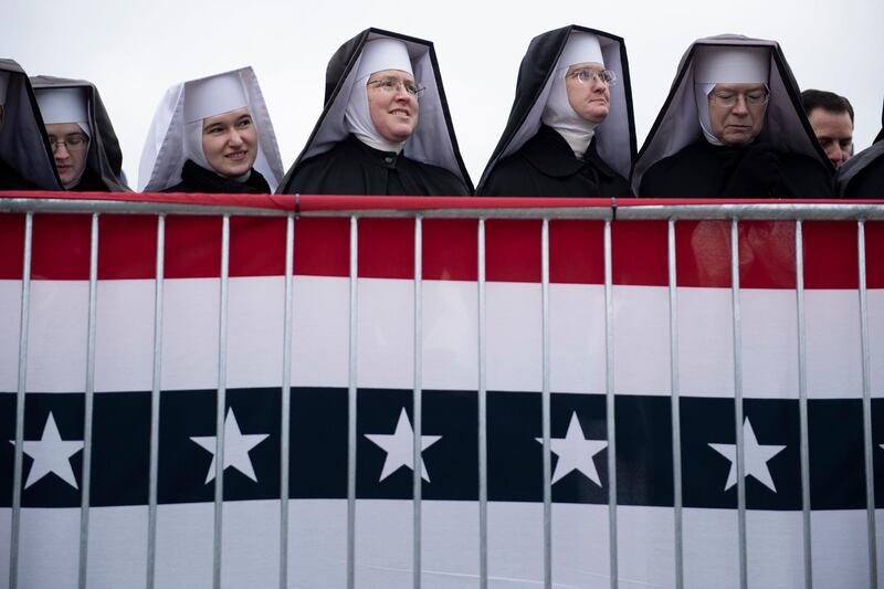 Little Sisters of the Poor wait for US President Donald Trump to speak during a "Make America Great Again" rally at Total Sports Park, in Washington, Michigan. AFP