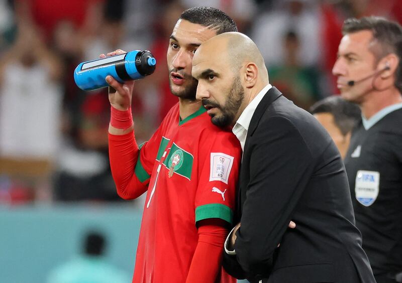 Morocco midfielder Hakim Ziyech talks with coach Walid Regragui. AFP