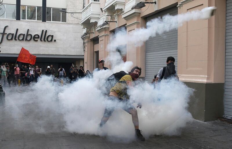 Demonstrators return tear gas canisters back towards police during clashes against the pardon of former President Alberto Fujimori in Lima, Peru. Martin Mejia / AP Photo