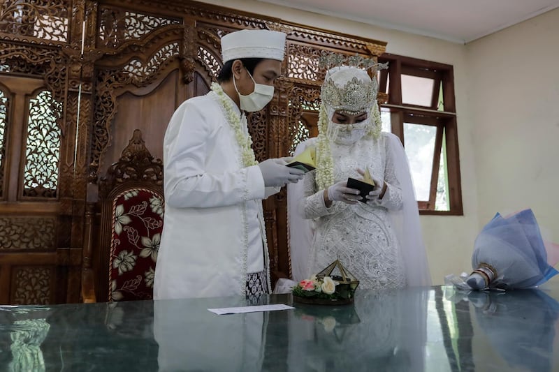 Groom Risky Ekky and his bride Veriana Fallah check their wedding documents during their wedding ceremony amid coronavirus outbreak in Jakarta, Indonesia. EPA