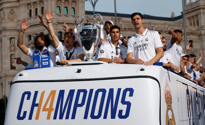 Real Madrid players Thibaut Courtois, Luka Modric, Marco Asensio, and Marcelo celebrate on an open top bus with the Champions League trophy. Reuters