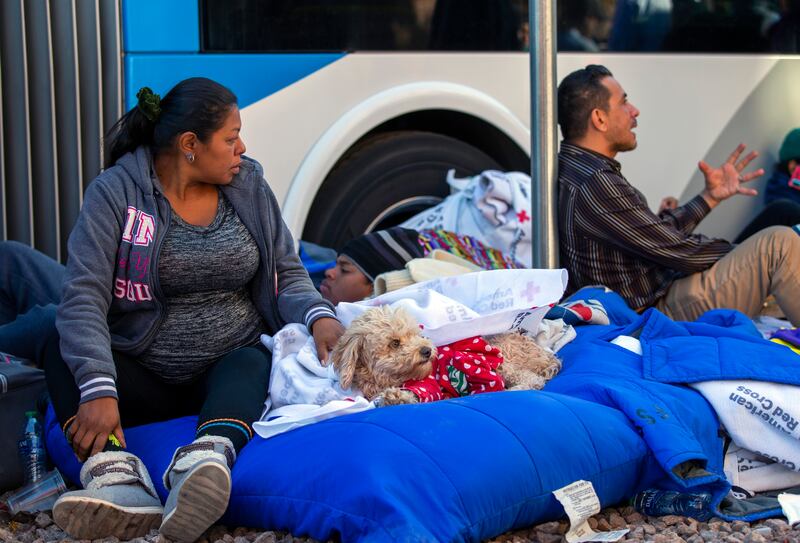 A Venezuelan migrant sits with her dog at an encampment outside the Sacred Heart Church. AP