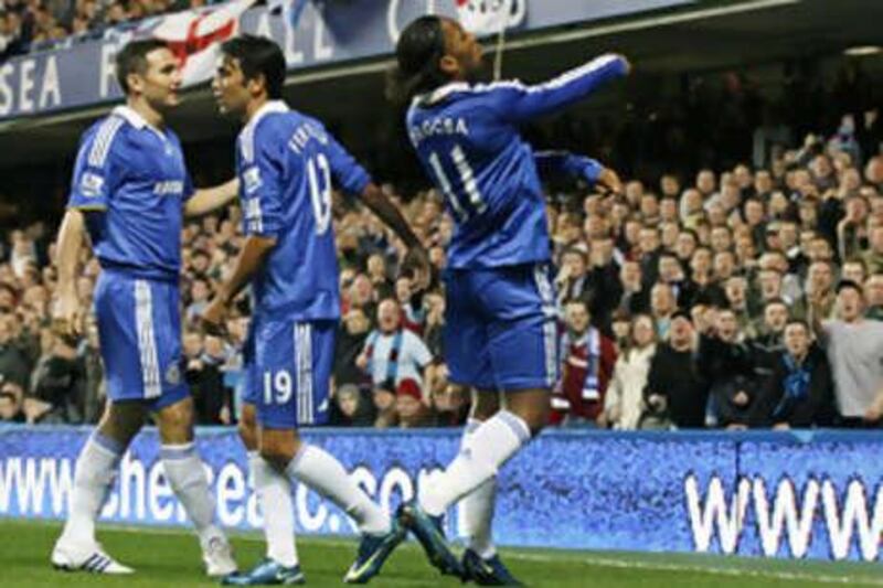 Didier Drogba, right, throws a coin back into the crowd during Chelsea's League Cup game against Burnley.