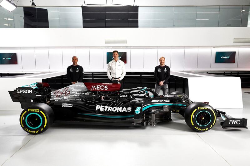 Team principal Toto Wolff, centre, with drivers Lewis Hamilton and Valtteri Bottas unveil the Mercedes W12 car at the new Race Bay facility in Brackley. PA