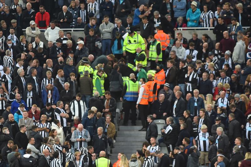 A Newcastle fans receives medical attention in the stands at St James' Park after collapsing during the game. EPA