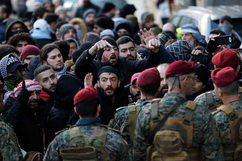 Lebanese army special forces block a road in front of anti-government protesters. AP Photo