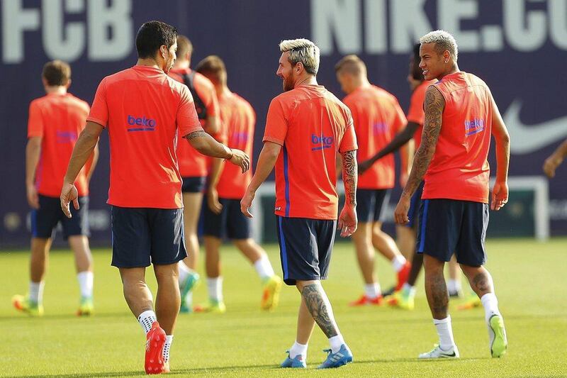Barcelona forwards Luis Suarez, left, Lionel Messi, centre, and Neymar talk during the training session. Alejandro Garcia / EPA