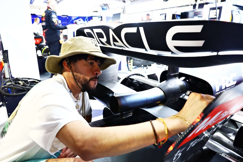 Rapper Bad Bunny signs the rear wing of Sergio Perez's Red Bull car prior to the F1 Grand Prix of Miami. AFP