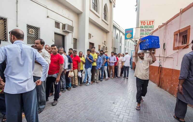 DUBAI,  UNITED ARAB EMIRATES, 20 May 2018 - People queueing to get  take away porridge for the iftar at Lootah Masjid Mosque, Deira, Dubai. Leslie Pableo for The National  for Ramola Talwar story