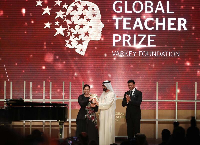 British teacher Andria Zafirakou (L) receives the "Global Teacher Prize" from Sheikh Mohammed bin Rashid al-Maktoum (C), Vice-President and Prime Minister of the UAE and Ruler of Dubai during an award ceremony in Dubai on March 18, 2018.
Zafirakou who  was among ten finalists chosen from 179 countries, won one million dollars of prize money. / AFP PHOTO / KARIM SAHIB