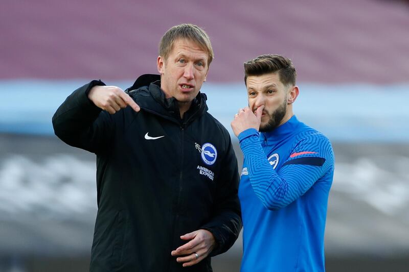 Brighton's head coach Graham Potter talks to Brighton's Adam Lallana, right, during a warmup prior to the English Premier League soccer match between West Ham and Brighton in London, England, Sunday, Dec. 27, 2020. (Paul Childs/Pool via AP)