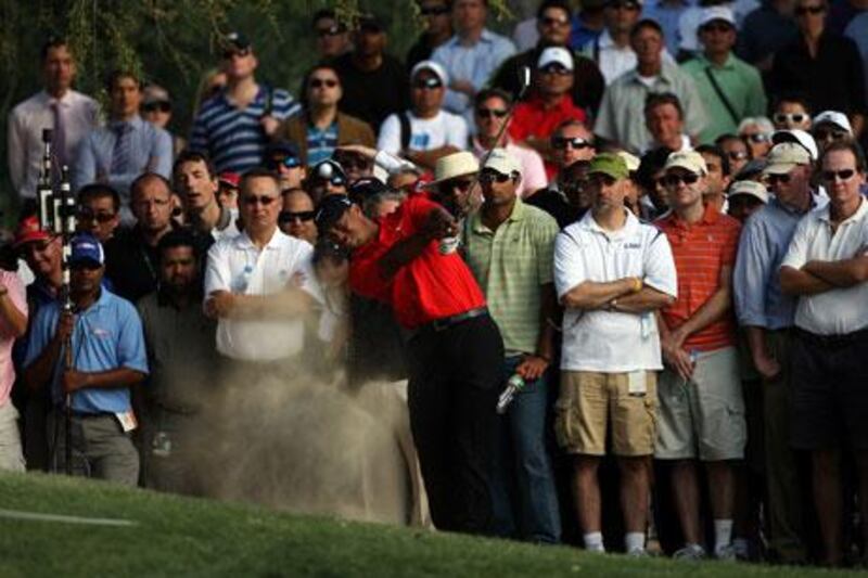 Tiger Woods tries to hack his way out of trouble on the Majlis Course in Dubai yesterday.
