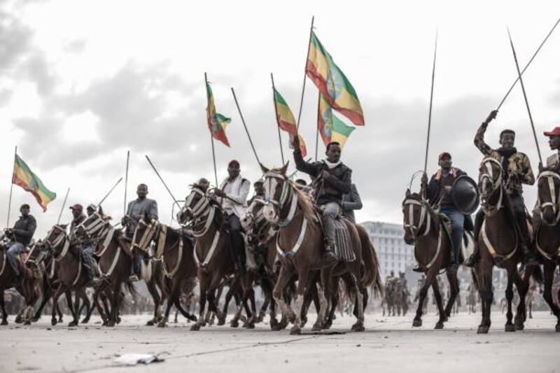 People on horseback wave the Ethiopian national flag during a rally to support armed forces in Addis Ababa.