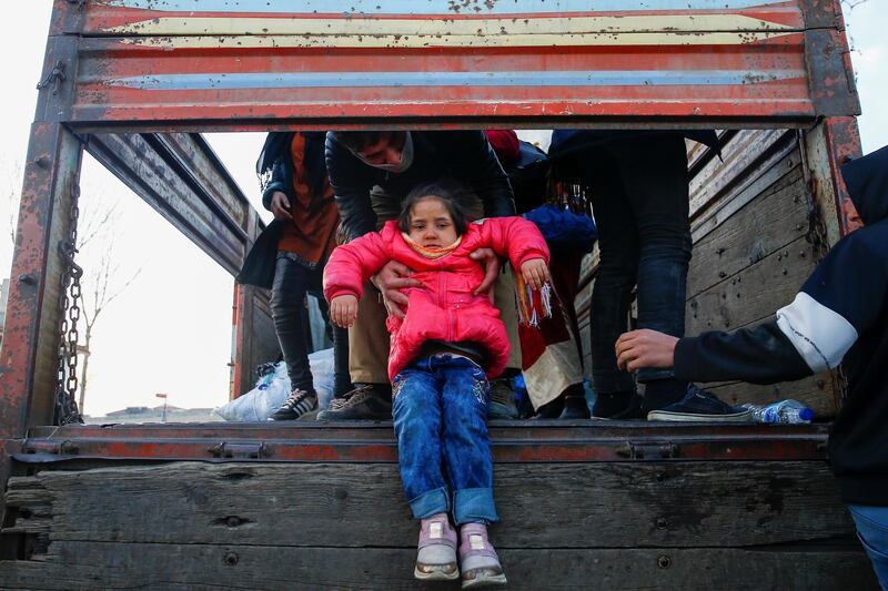 A migrant child is passed from a truck near the Turkey's Pazarkule border crossing with Greece's Kastanies, near Edirne, Turkey. REUTERS