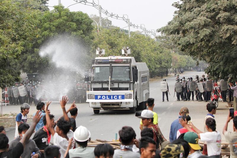 Police officers stand in front of people who protest against the military coup, in Mandalay, Myanmar. Reuters