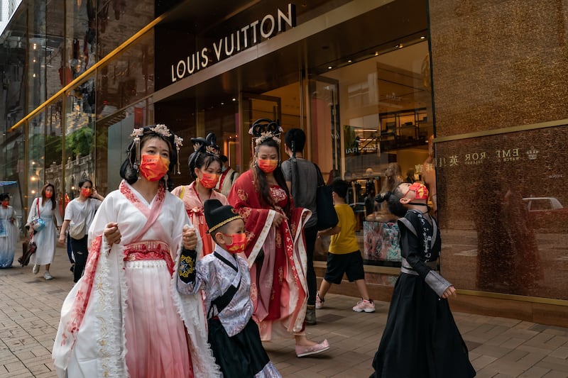 People walk past a Louis Vuitton store as they celebrate National Day in Hong Kong in 2022