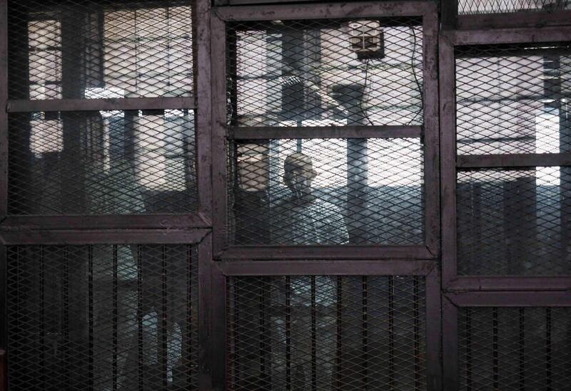 One of 24 defendants including Alaa Abdel-Fattah, a prominent activist, appears in the cage on charges they organised an unauthorized protest in November last year, while in a trial in Cairo, Egypt. Hamada Elrasam / AP Photo