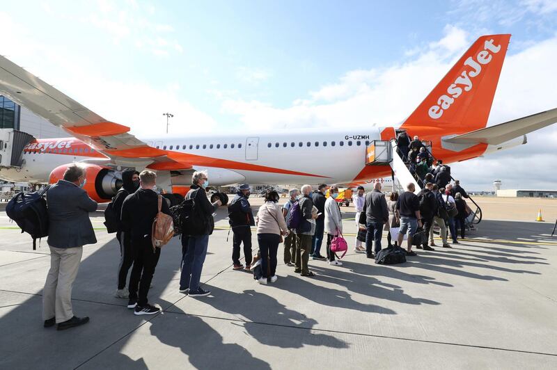 Passengers prepare to board a flight bound for Faro, Portugal, at Gatwick Airport. AP Photo