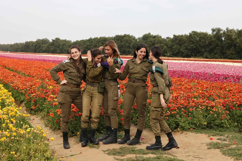 Israeli soldiers visit a ranunculus field at Nir Yitzhak kibbutz. Ranunculus flowers come in colours including pink, red, purple, cream, yellow and orange. AFP